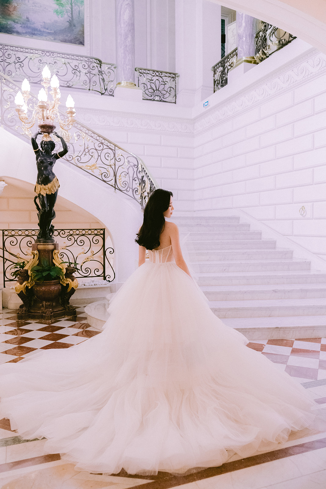 the bride poses in front of the stairs for the photo
